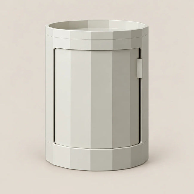 A minimalist, geometric cylindrical side table or cabinet with a faceted, low-poly design in a light gray color, set against a solid beige background.