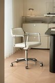 White office chair with chrome frame in a modern office setting