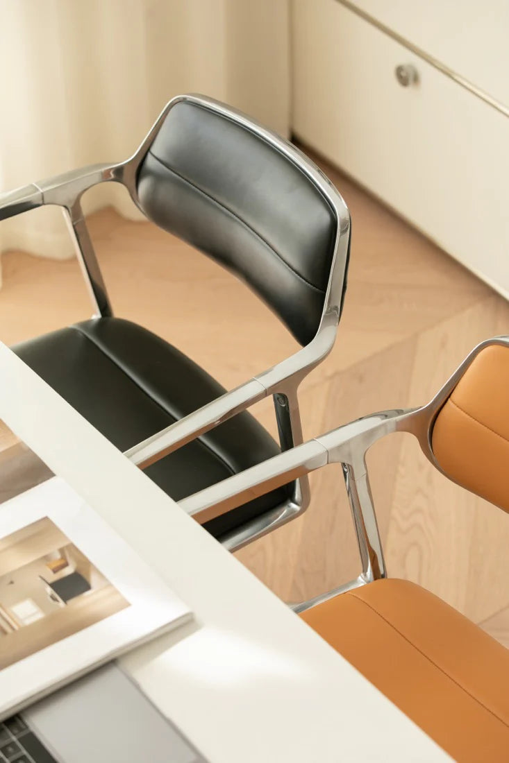 Modern office chair with a metallic frame and black seat in an office setting.