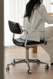Person sitting on a black office chair with a blurred background