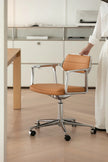 Brown office chair with metal frame on a wooden floor in an office setting