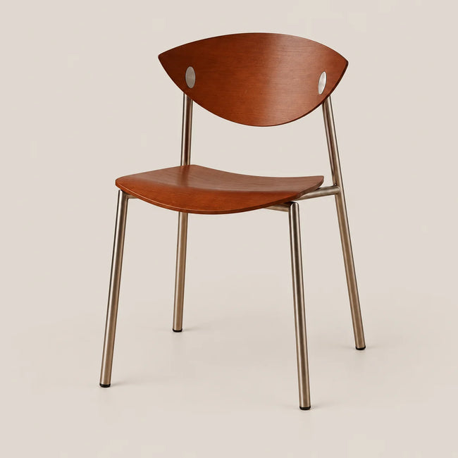 A modern dining chair with a curved medium-brown wooden seat and backrest, supported by slim metallic legs, shown against a solid light beige background.