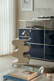 Modern interior with a sideboard, decorative shelf, and books.
