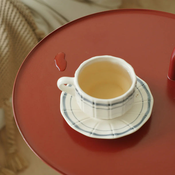 Teacup and saucer on a red surface