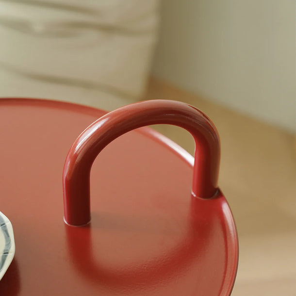 Close-up of a red pot lid on a wooden surface