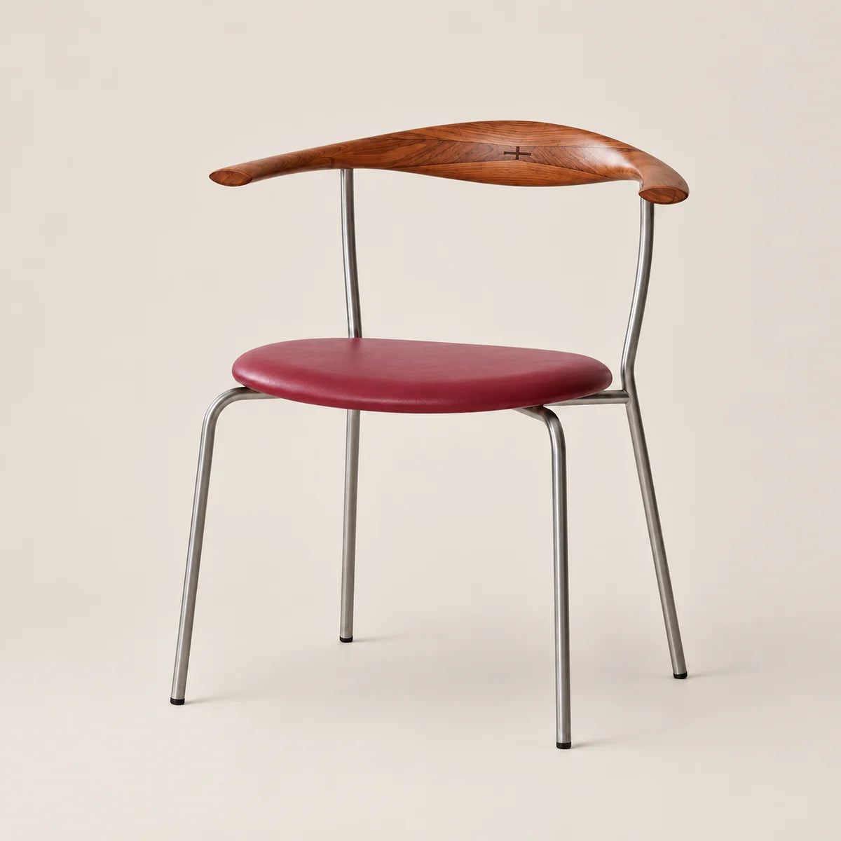 A mid-century modern dining chair featuring a curved wooden backrest, a red upholstered seat, and a slim silver metal frame, set against a solid light beige background.