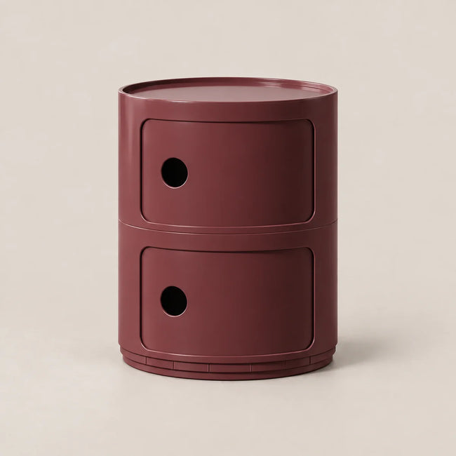 A modern two-tier cylindrical side table or storage unit in a matte burgundy finish, set against a clean, warm off-white background.