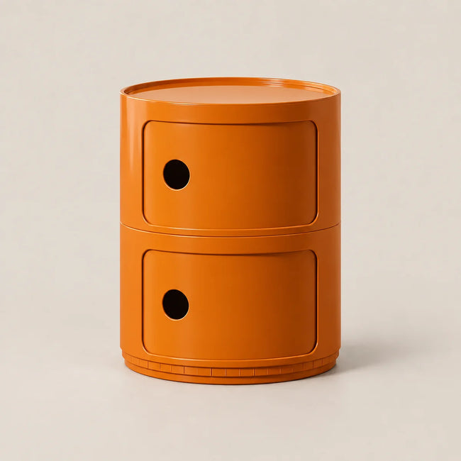 An orange cylindrical two-drawer nightstand with a matte finish, featuring circular cutouts on the drawer fronts, set against a solid light beige background.
