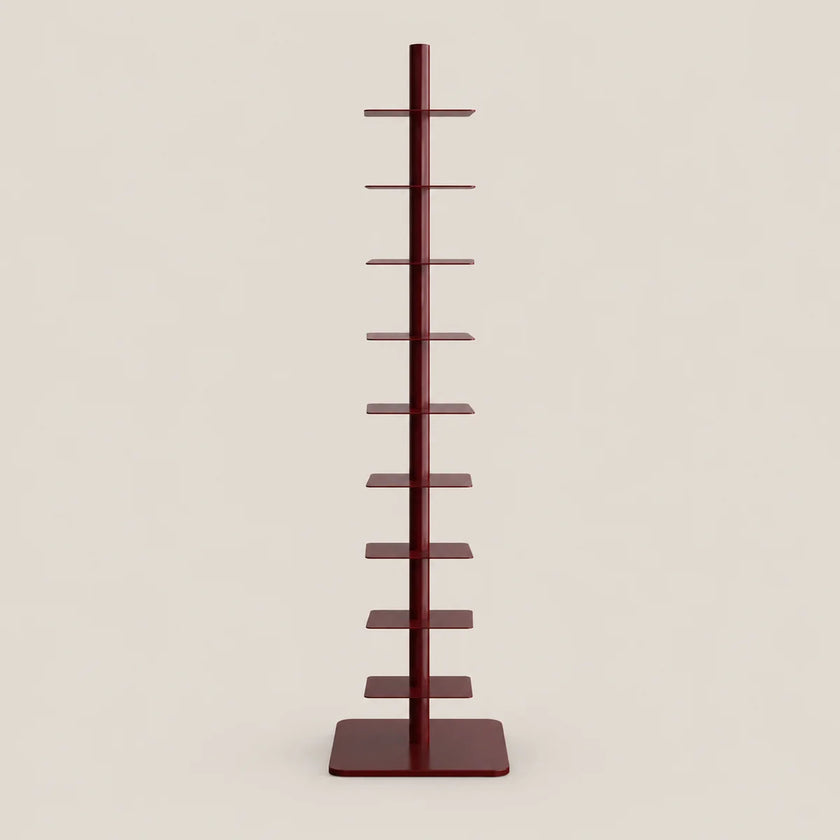 A tall, narrow multi-tier display stand with a central vertical pole and multiple flat horizontal shelves, finished in a dark reddish-brown color, set against a solid light beige background.