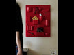A glossy red, wall-mounted ABS organizer board featuring a variety of geometric compartments, pockets, and holders—including square boxes, curved bowls, and cylindrical cups—designed for storing small items and displaying books or magazines.