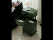 An olive-green drawer storage cart placed beside the sofa, inspired by MoMA.