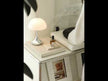 A modular white shelving unit with a stainless steel frame, designed for storing vinyl records and audio equipment.