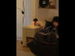 An off-white, multi-functional storage cart sits beside the sofa, where a woman is lying down reading a book.
