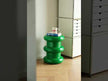 A striking, glossy green sculptural side table with a playful, stacked-ring design, featuring three bulbous, rounded tiers and a shiny, reflective finish.