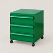 A bright green three-drawer rolling storage cabinet with black caster wheels, shown on a plain light beige studio background.