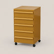 A six-drawer rolling file cabinet in a glossy mustard yellow finish with black caster wheels, shown on a plain light beige studio background.