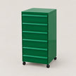 A green 6-drawer rolling tool cabinet with black caster wheels, shown on a light beige studio background.