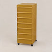 A golden yellow 7-drawer rolling file cabinet with black caster wheels, photographed against a neutral light gray studio background.