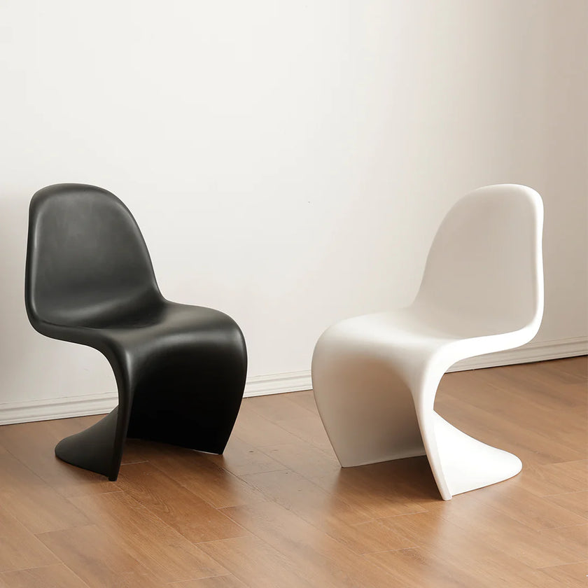 Black and white chairs on a wooden floor with a white wall background