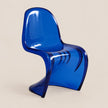 A translucent blue molded chair with a sculptural curved silhouette, photographed against a plain warm beige studio background.