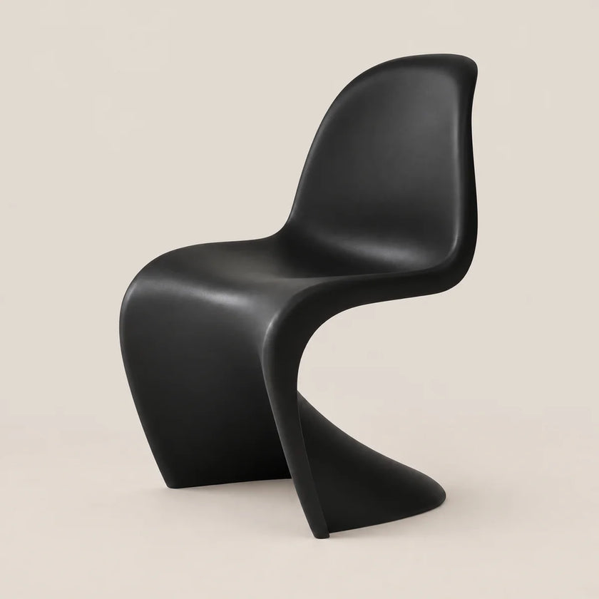 A modern sculptural black chair with a curved shell seat and integrated base, photographed against a plain warm beige studio background.
