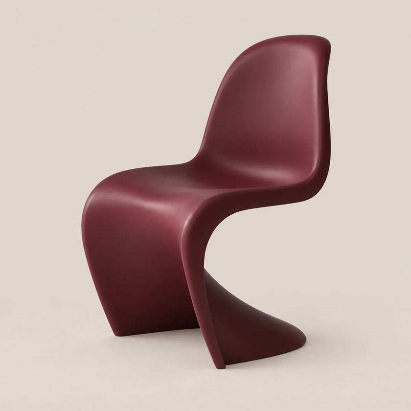 A modern sculptural chair in a deep burgundy color, shown from a three-quarters angle against a solid light beige background.