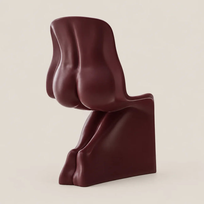 A sculptural molded chair in a deep burgundy color, photographed from the side against a solid light beige background.