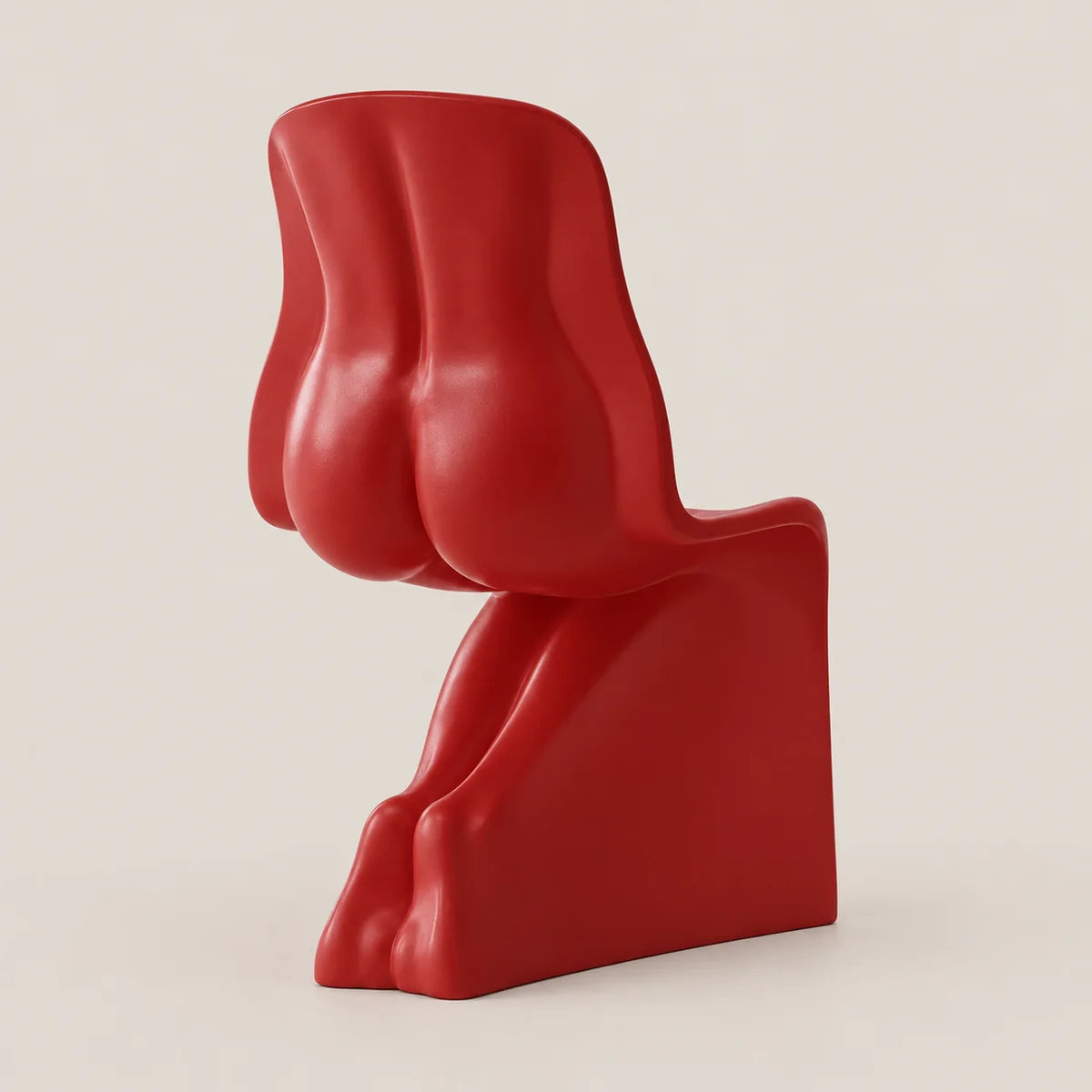 A bold, sculptural red chair with an abstract, organic shape, photographed against a solid, warm off-white background.