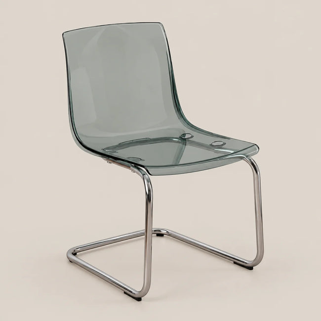 A modern cantilever dining chair with a translucent smoky green seat and backrest, supported by a polished chrome metal base, shown against a solid beige background.