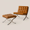 A modern leather lounge chair with a matching ottoman, featuring tufted tan leather upholstery and chrome X-frame legs, set against a solid light beige background.