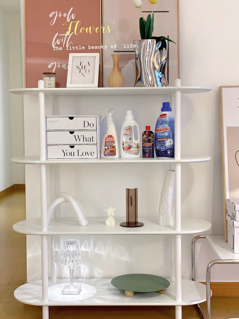 White shelving unit with various items on a wooden floor.