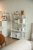 White shelving unit with various items in a room setting