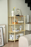 Light wooden shelf with decorative items against a neutral wall.