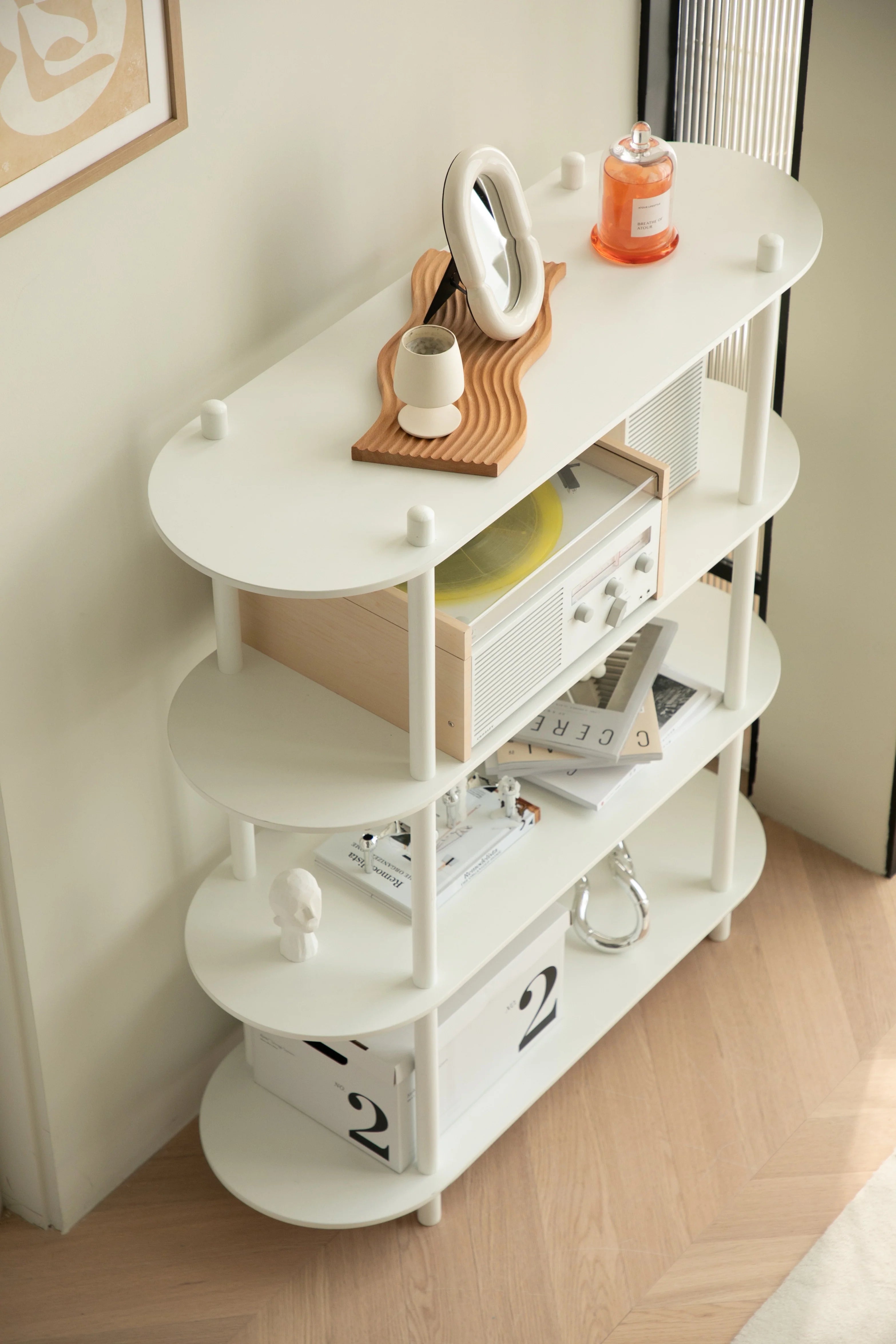 White shelf with various items against a white wall