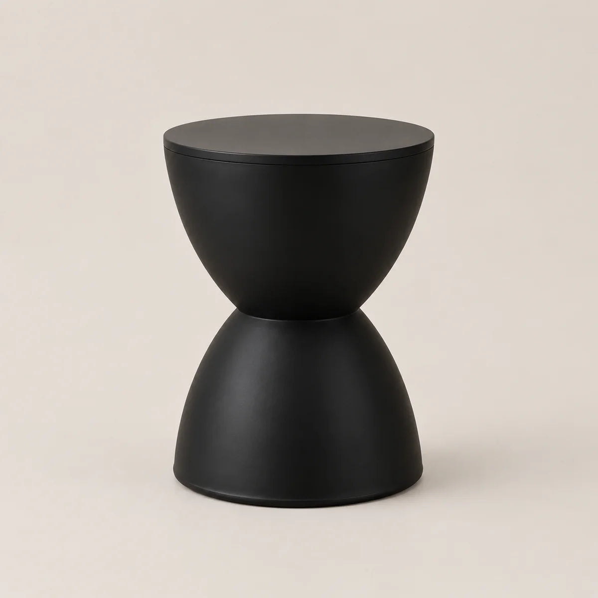 A minimalist black side table with a sculptural hourglass-like design, featuring a matte finish on a warm beige background.