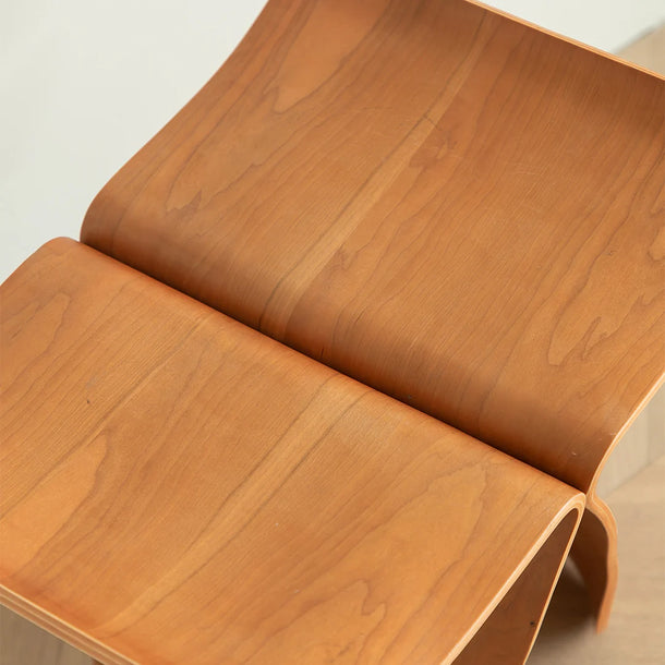 Wooden chair with a curved design on a plain background
