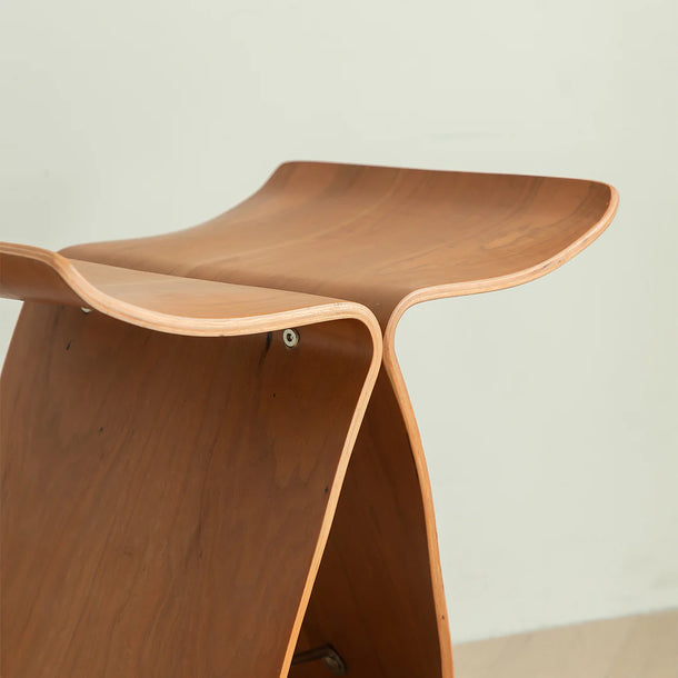 Wooden stool with a curved design on a plain background