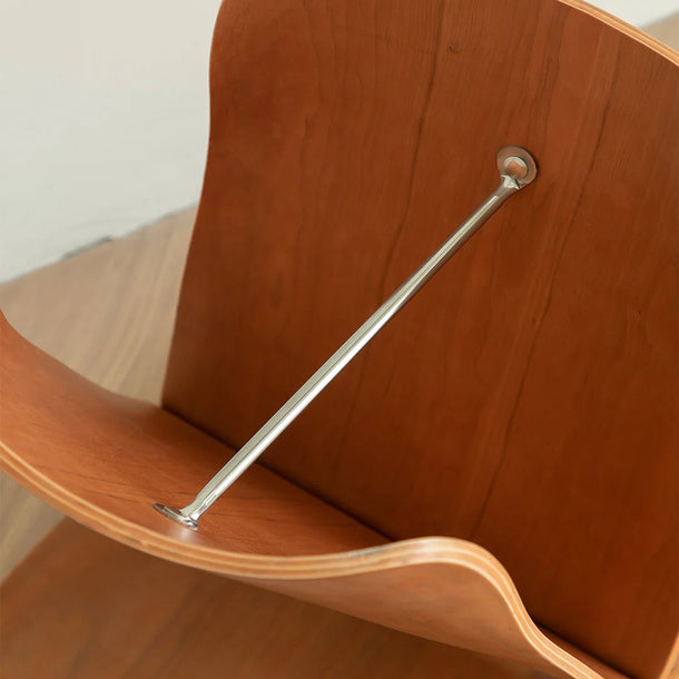 Wooden chair with metal bracket on a neutral background