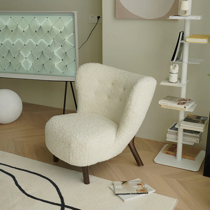 White textured chair in a modern room with a shelf and decorative items.