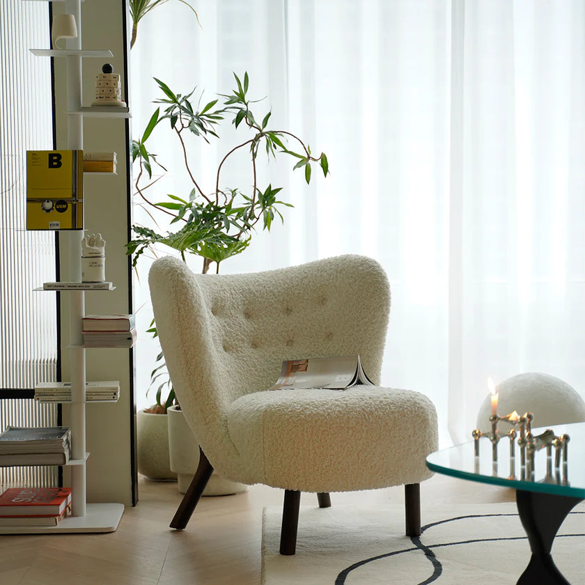 White textured armchair in a room with plants and a glass table.