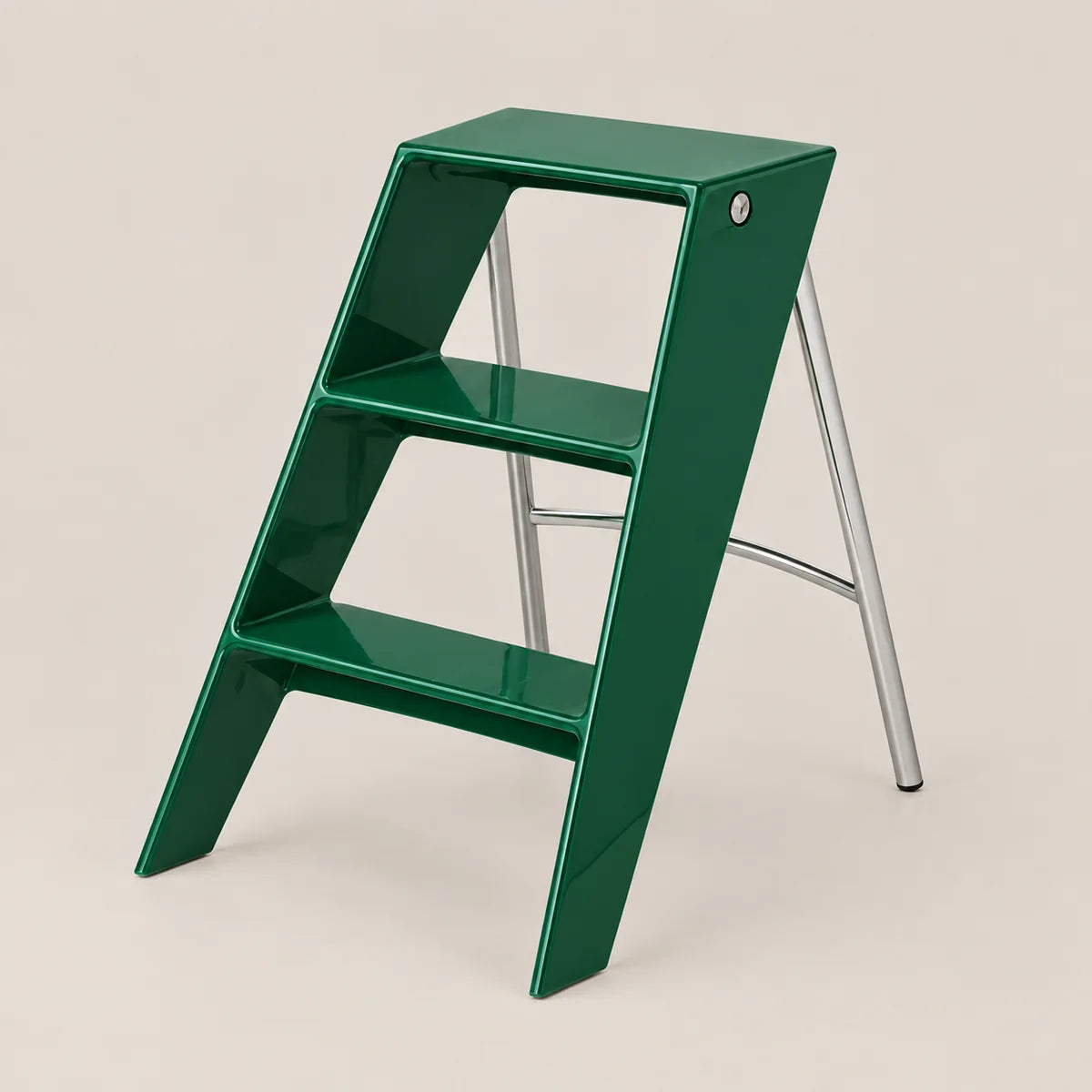A three-step step ladder with a glossy dark green plastic frame and silver metal legs, shown on a solid light beige background.