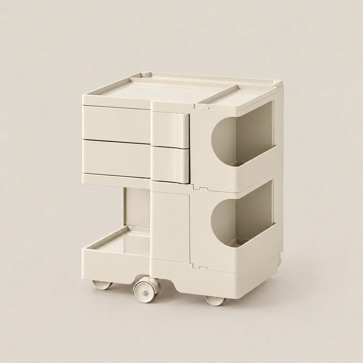 A modern, minimalist two-tier storage cart in a warm off-white/cream color, featuring three drawers on the top tier, open storage compartments with curved cutouts on the side, and a bottom pull-out drawer on wheels, set against a solid light beige background.