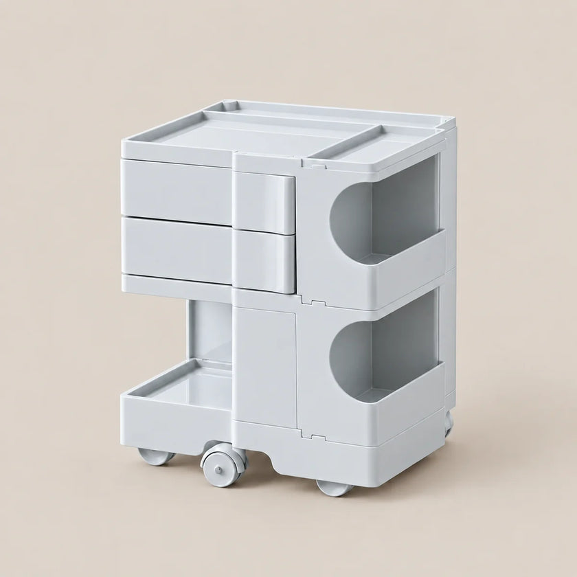 A light gray plastic rolling organizer cart with three drawers, two open side compartments, and a pull-out bottom tray, shown on a plain beige background.