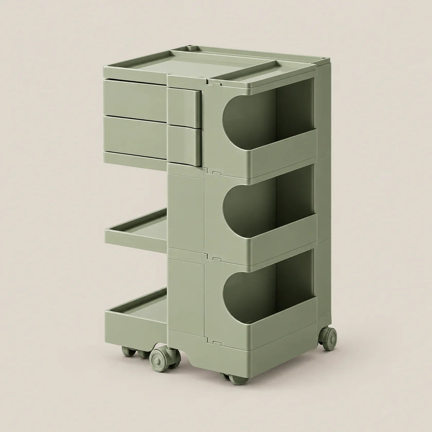A three-tier rolling storage cart in a muted sage green color, featuring three drawers on the top level, open shelves in the middle, and a lower tray on wheels, set against a solid light beige background.