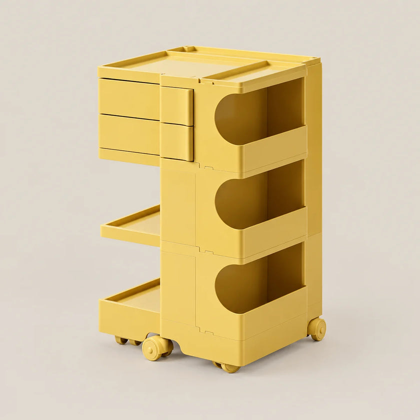 A bright yellow modular rolling storage cart with three drawers, three open shelves, and caster wheels, shown on a clean light beige studio background.