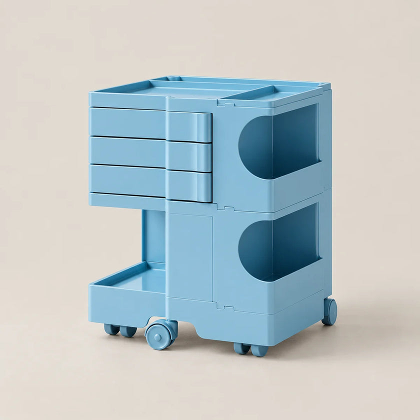 A light blue modular storage cart with three drawers, open shelves, and caster wheels, shown on a plain beige background.