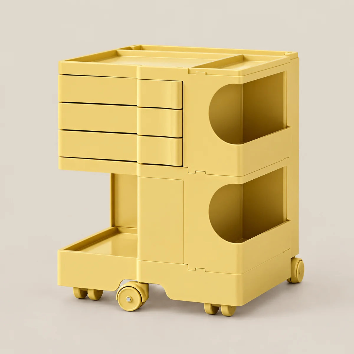 A bright yellow plastic rolling storage cart with three drawers on the top section, two open circular storage compartments, and a lower tray, shown on a light beige background.