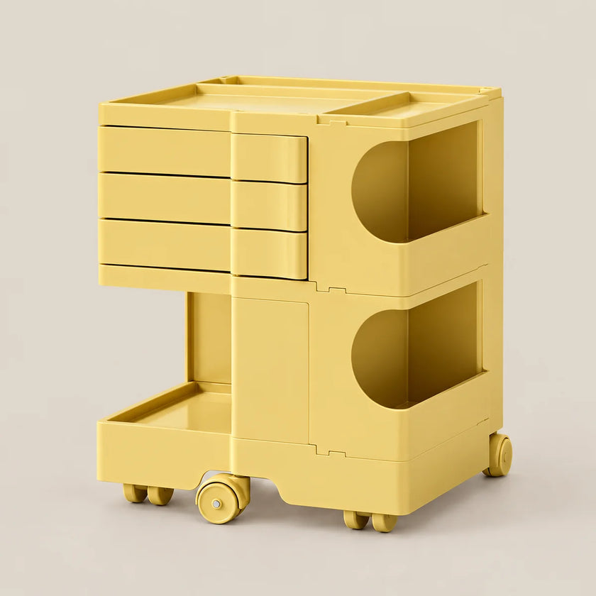 A bright yellow plastic rolling storage cart with three drawers on the top section, two open circular storage compartments, and a lower tray, shown on a light beige background.