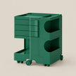 A dark green modular rolling storage cart with multiple drawers, open shelves, and caster wheels, shown on a plain beige studio background.