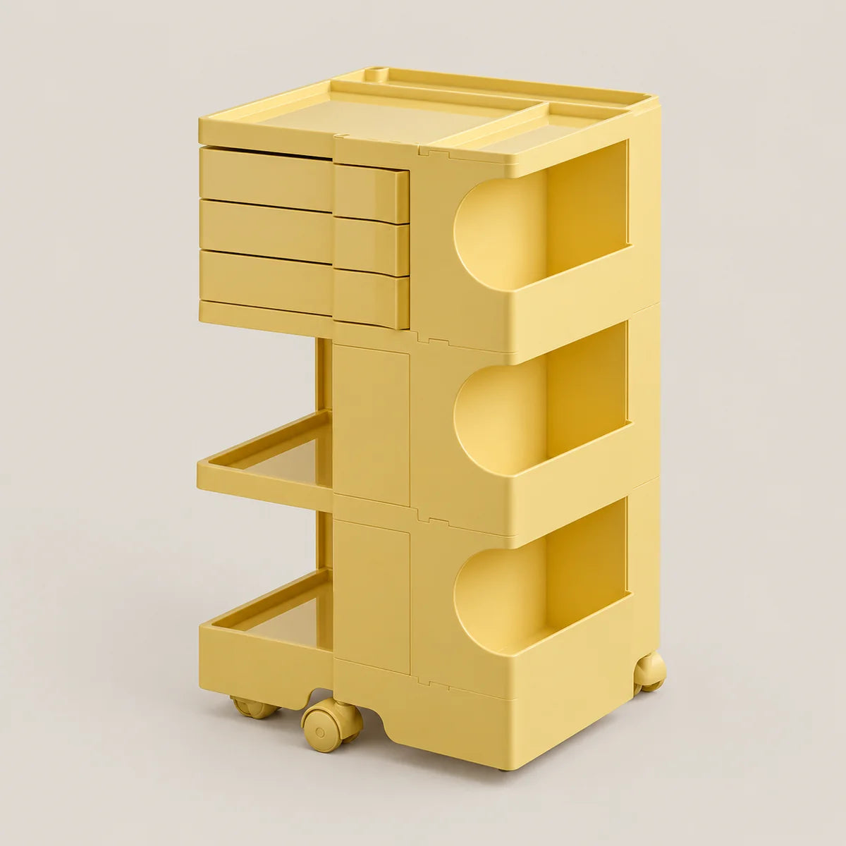 A yellow plastic rolling storage cart with three drawers on the left, three open shelves with circular cutouts on the right, and caster wheels at the base, shown on a plain light gray studio background.